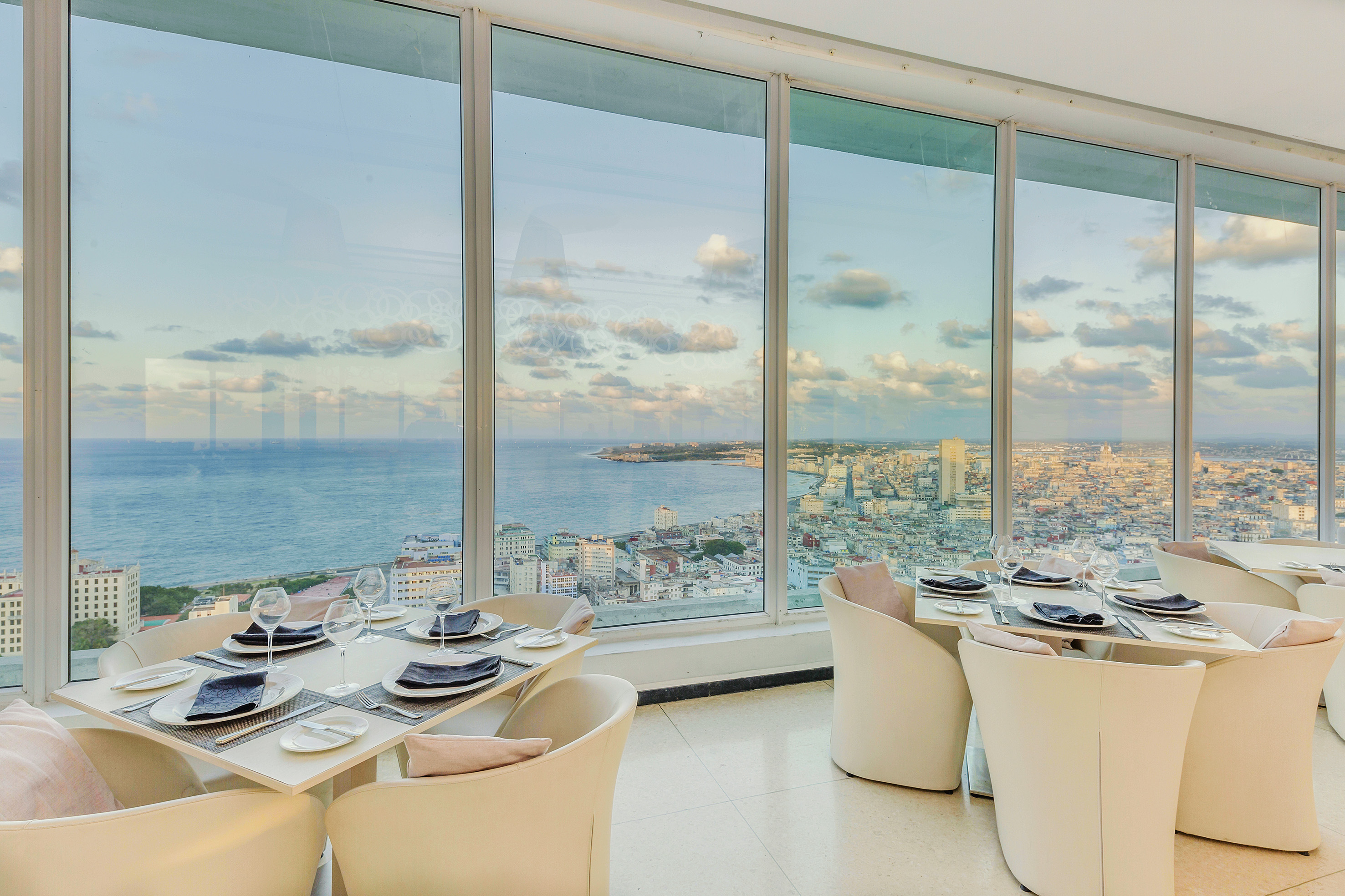 a dining room with large windows overlooking a city