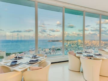 a dining room with large windows overlooking a city