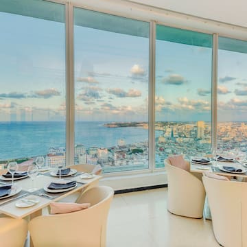 a dining room with large windows overlooking a city
