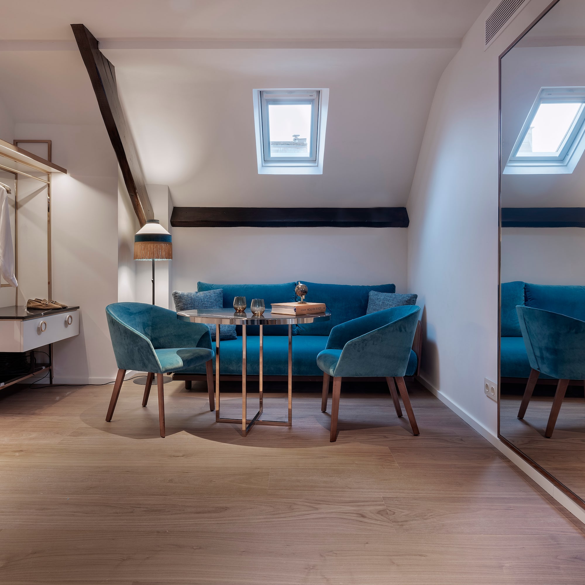 a room with a mirror and blue chairs