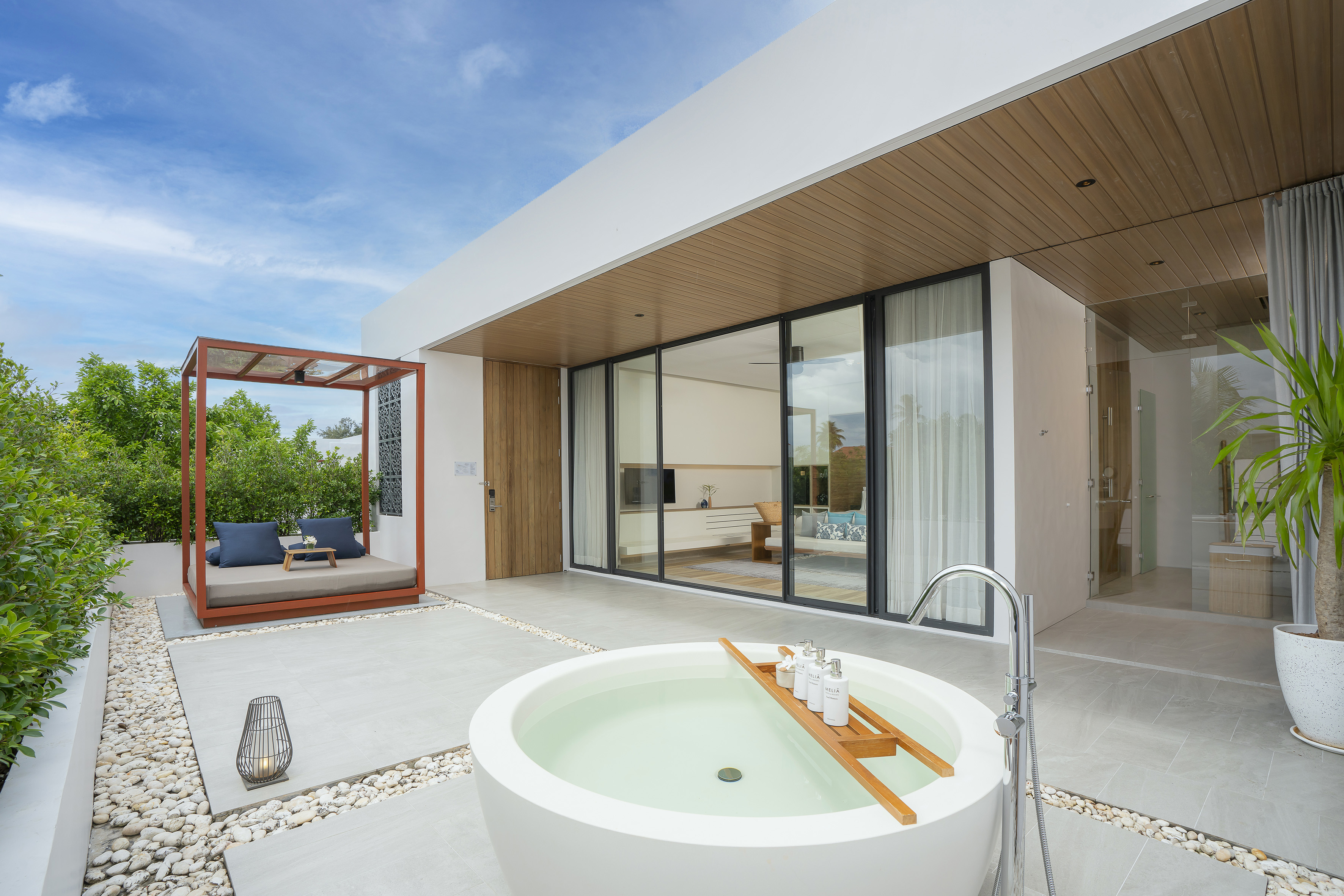 Luxury resort patio with outdoor bathtub, daybed, and modern design.