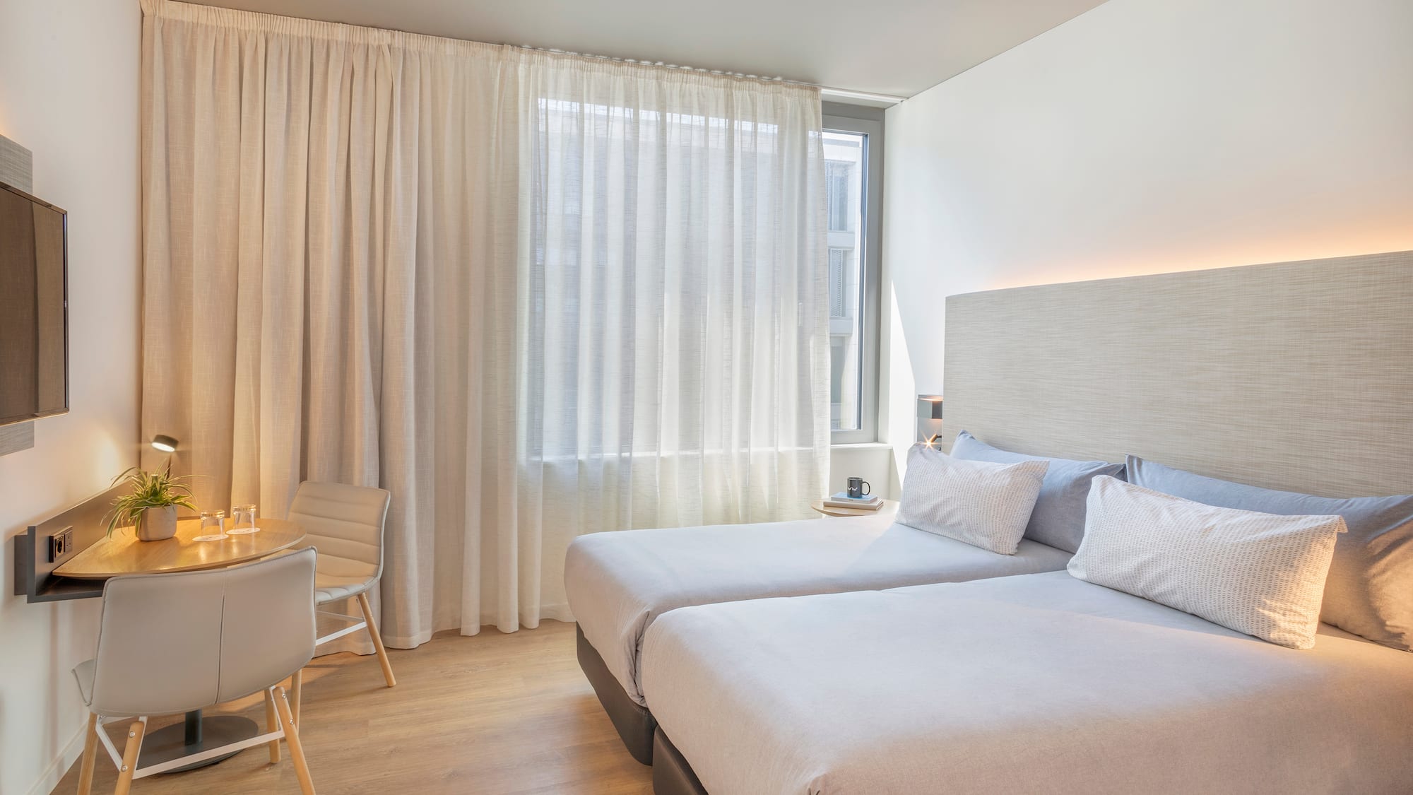 a room with two beds and a desk