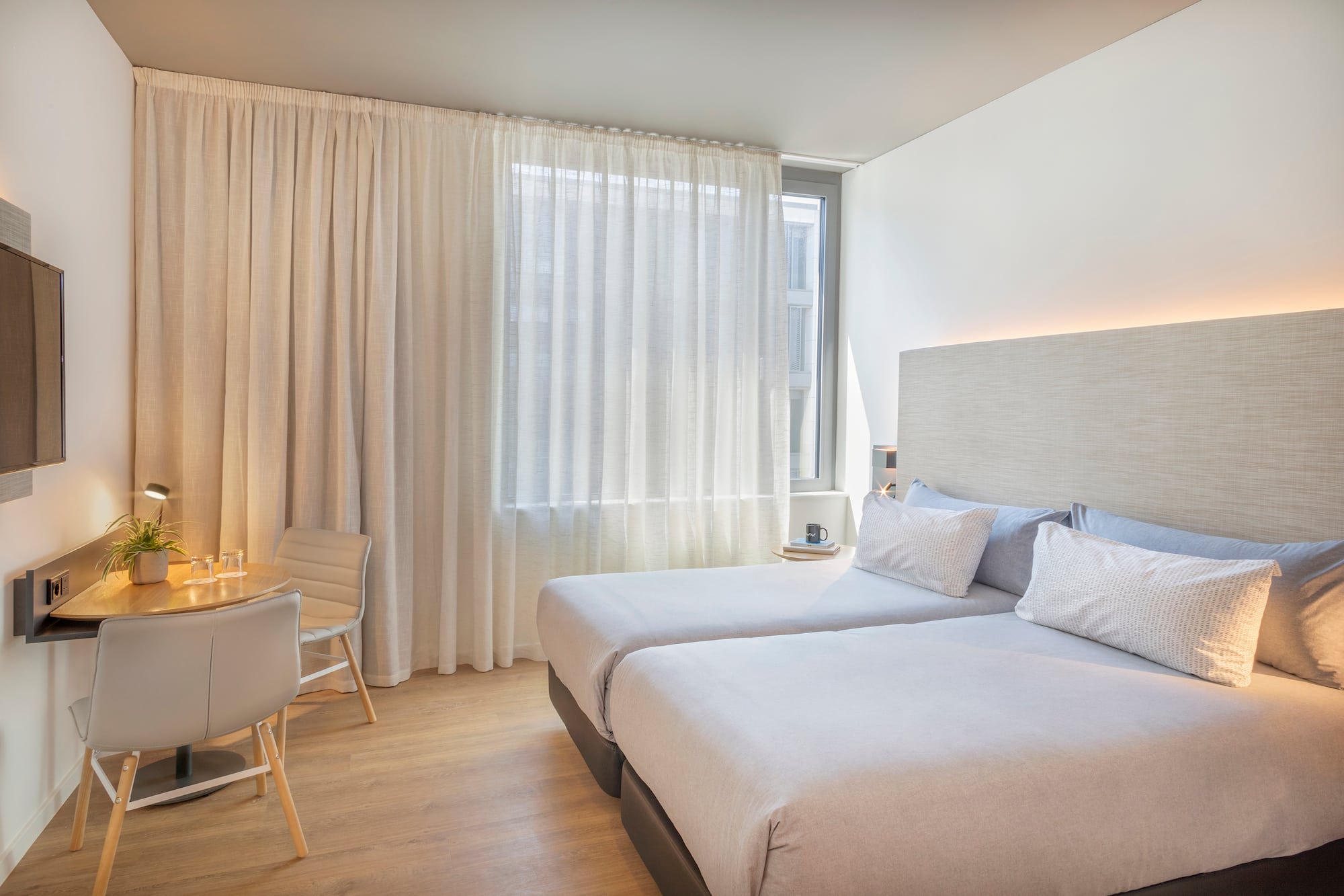 a room with two beds and a desk