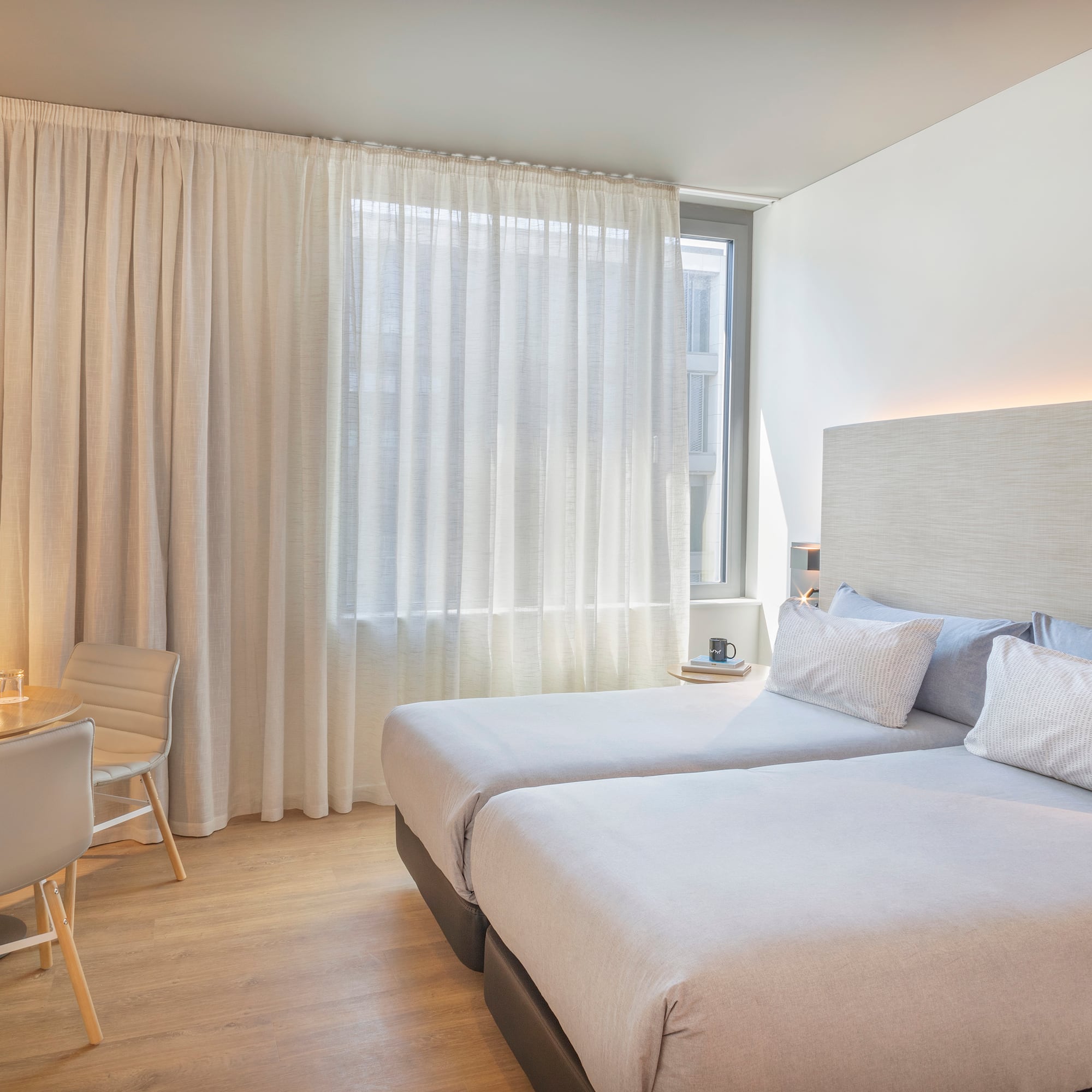 a room with two beds and a desk