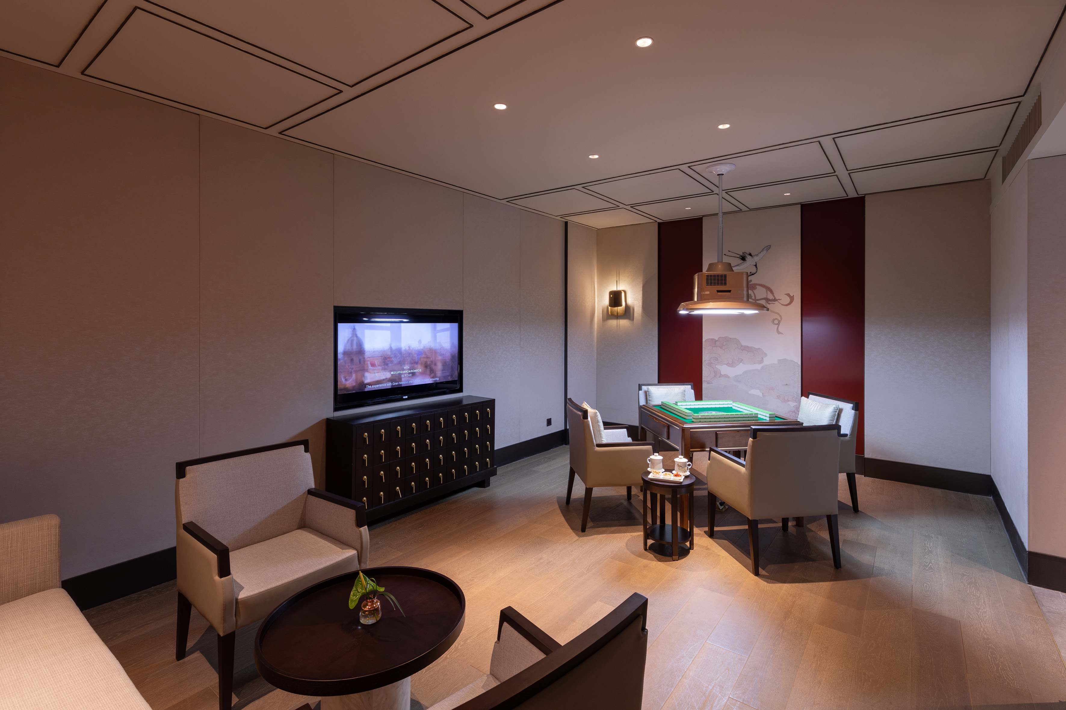 Modern mahjong room with TV, seating, and Asian-inspired wall decor.