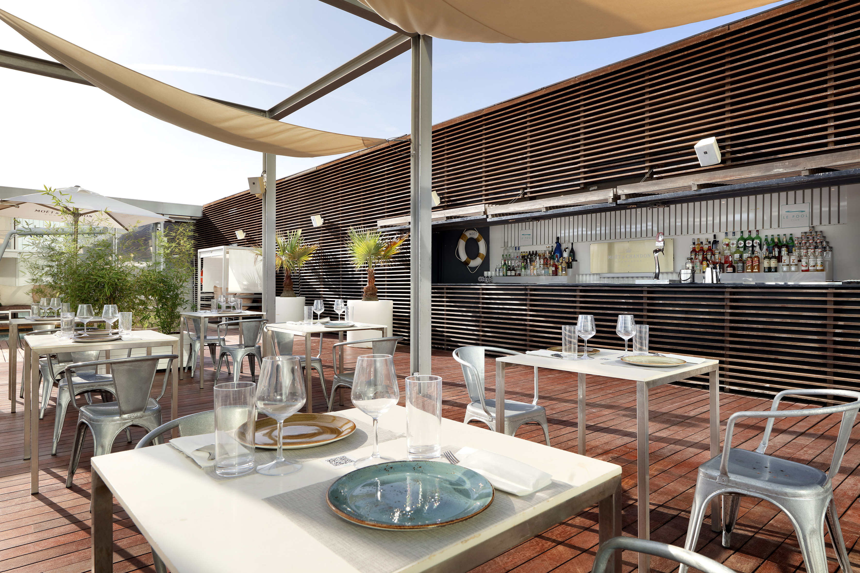 Sunny al fresco rooftop restaurant and bar, wooden deck.