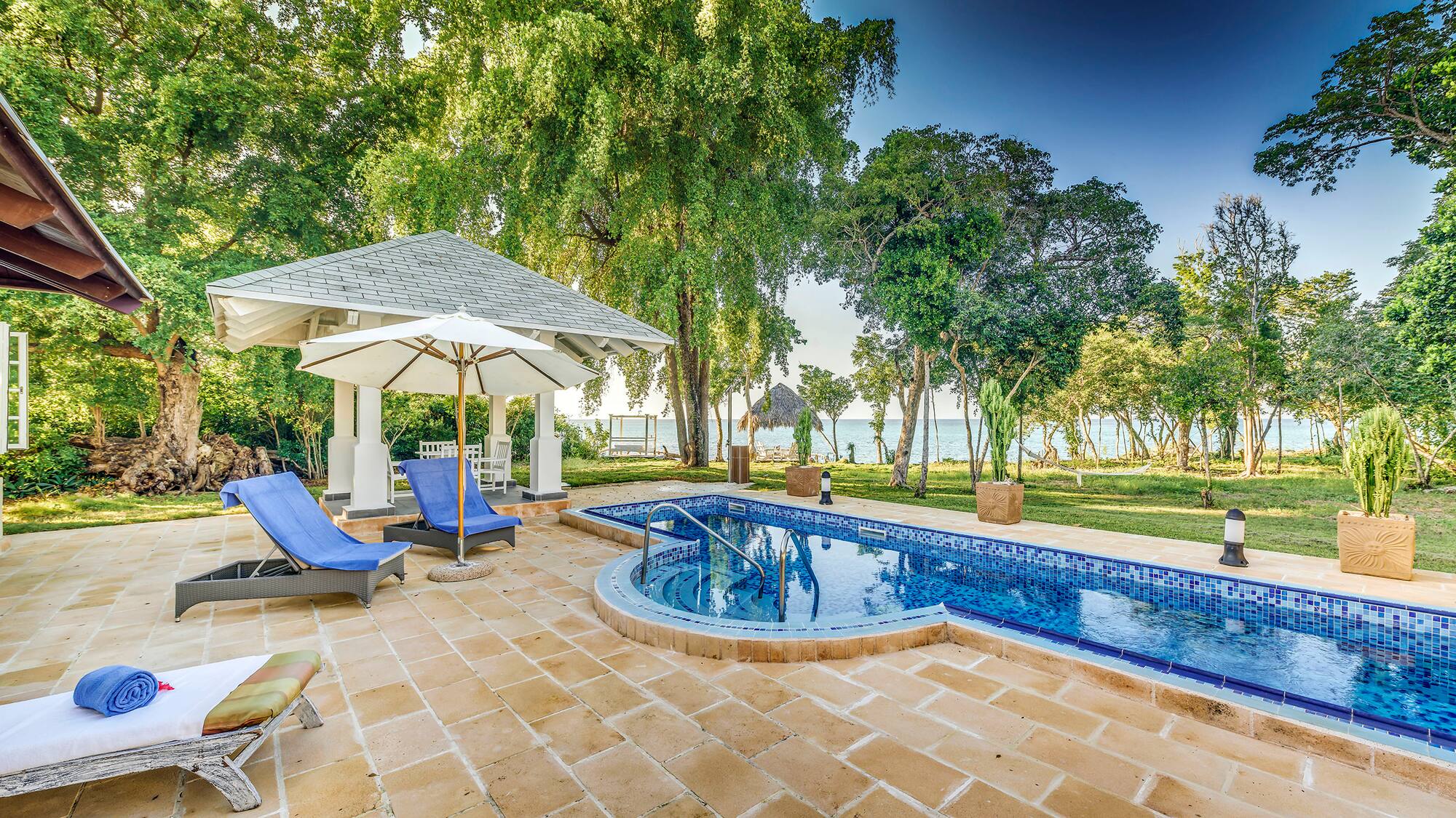 a pool with a deck chair and umbrella
