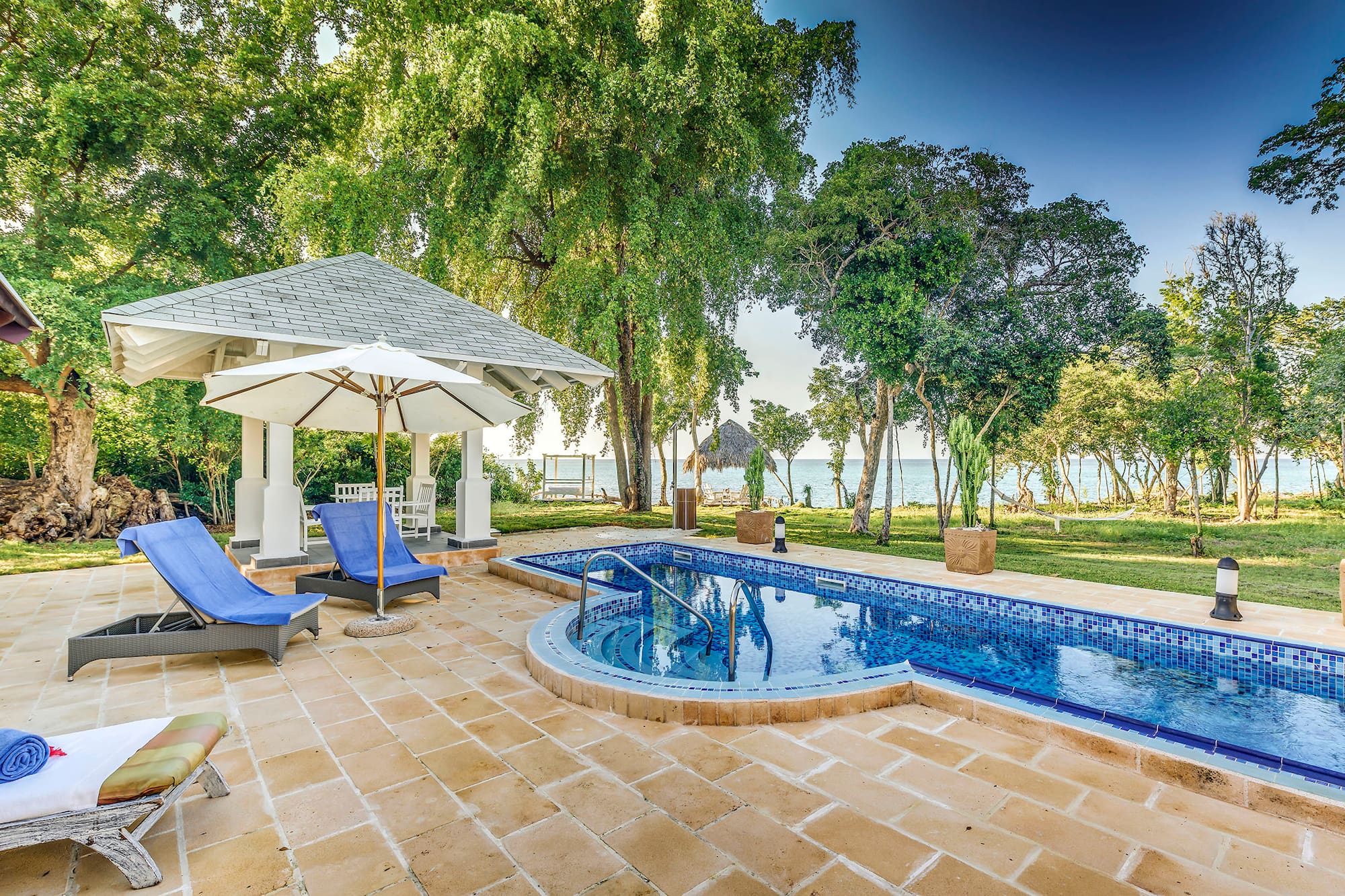 a pool with a deck chair and umbrella