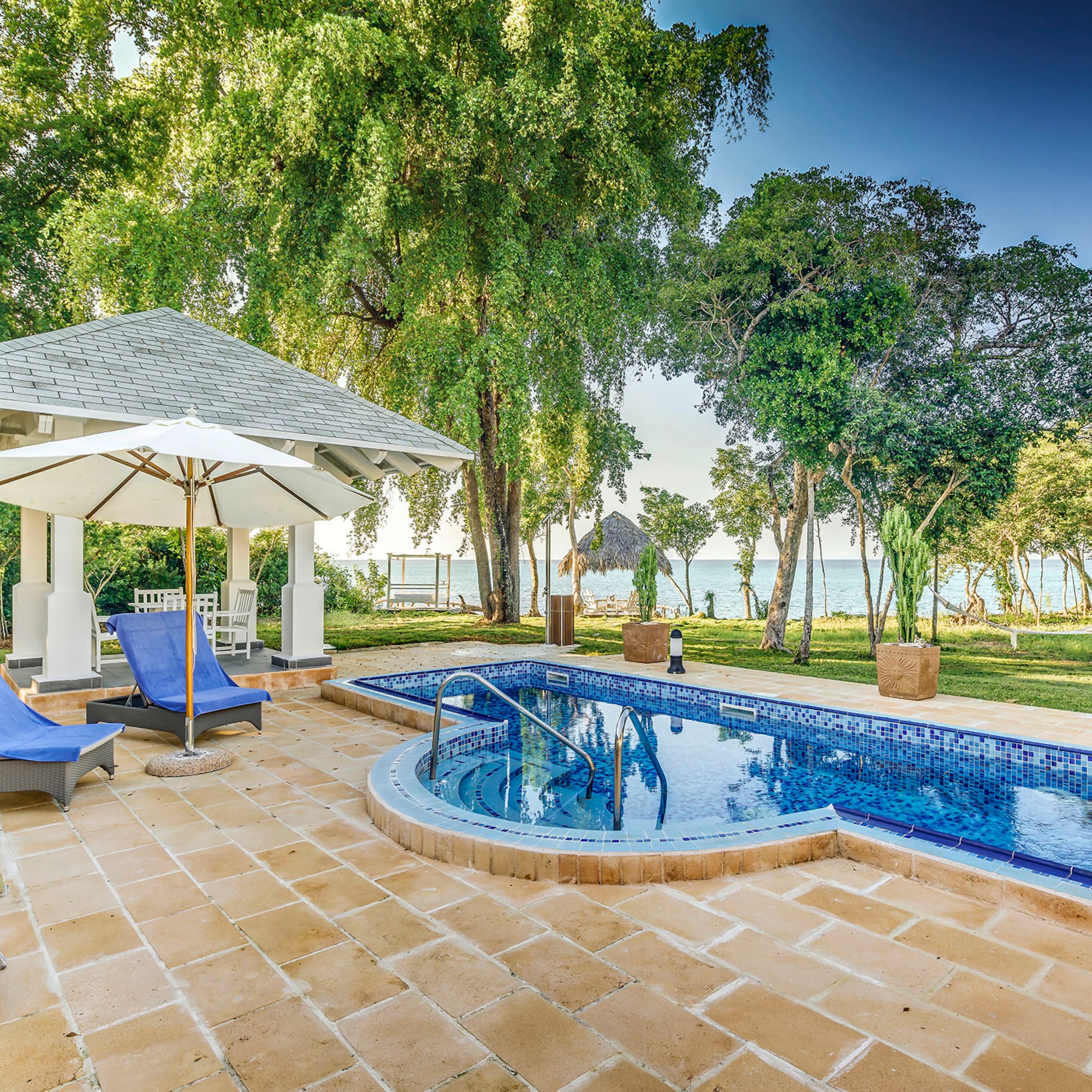 a pool with a deck chair and umbrella