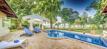 a pool with a deck chair and umbrella