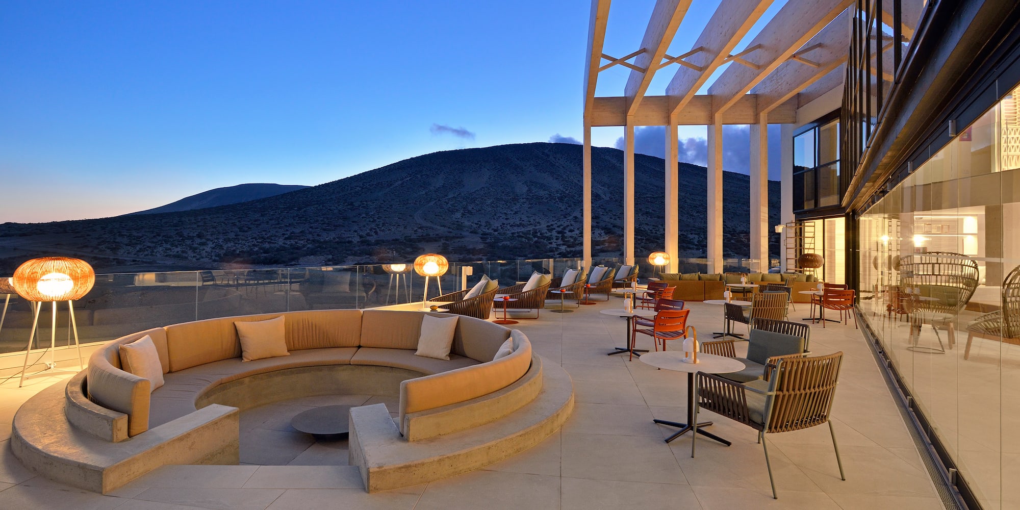 a large outdoor patio with a round couch and tables