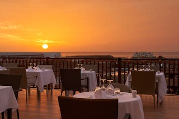 a table set up on a deck with a sunset in the background