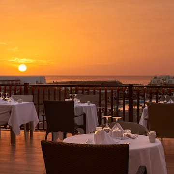a table set up on a deck with a sunset in the background