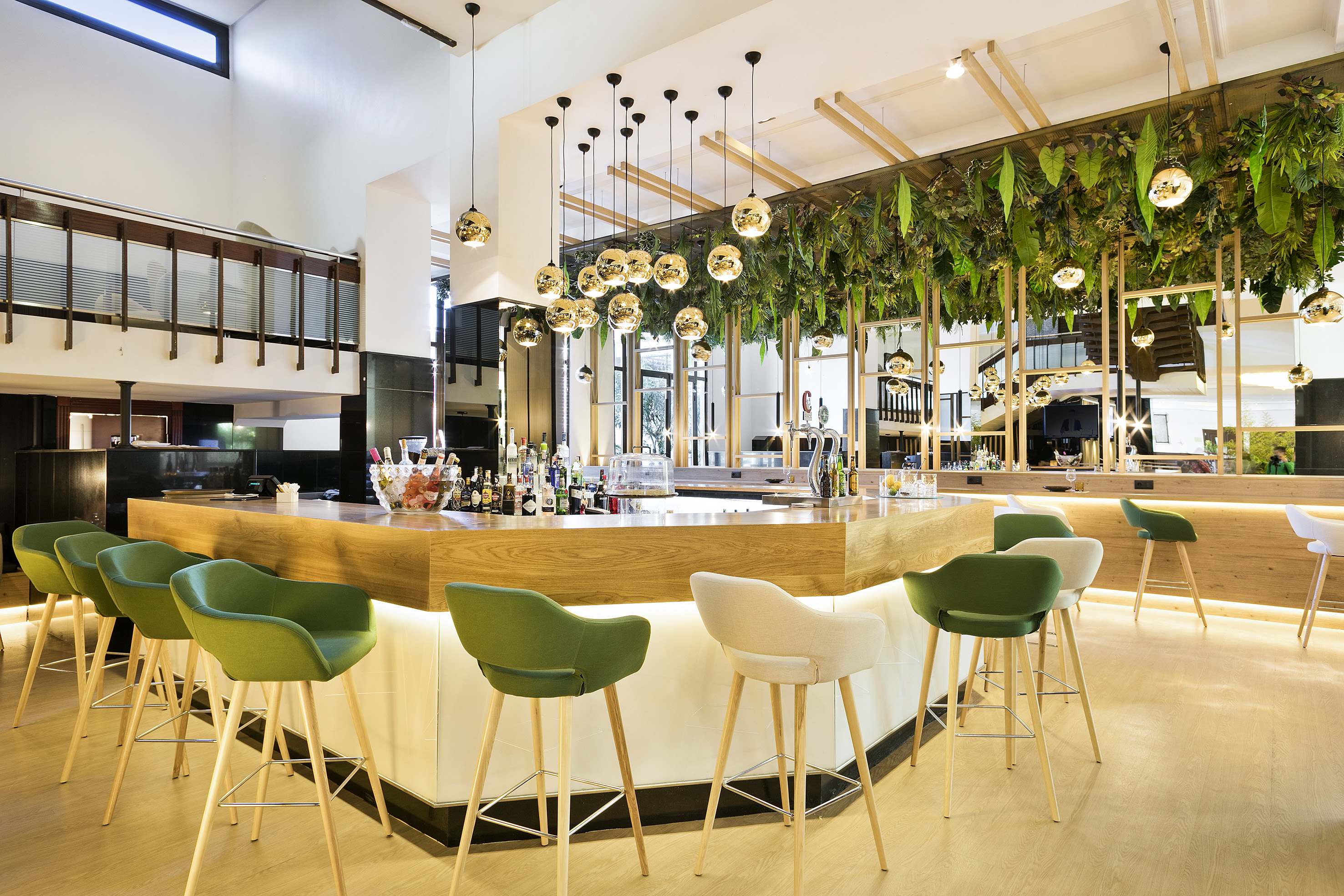 a bar with green chairs and a white counter