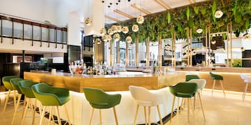 a bar with green chairs and a white counter