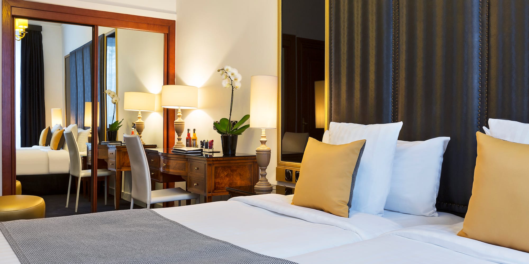 a bed with white sheets and pillows in a hotel room