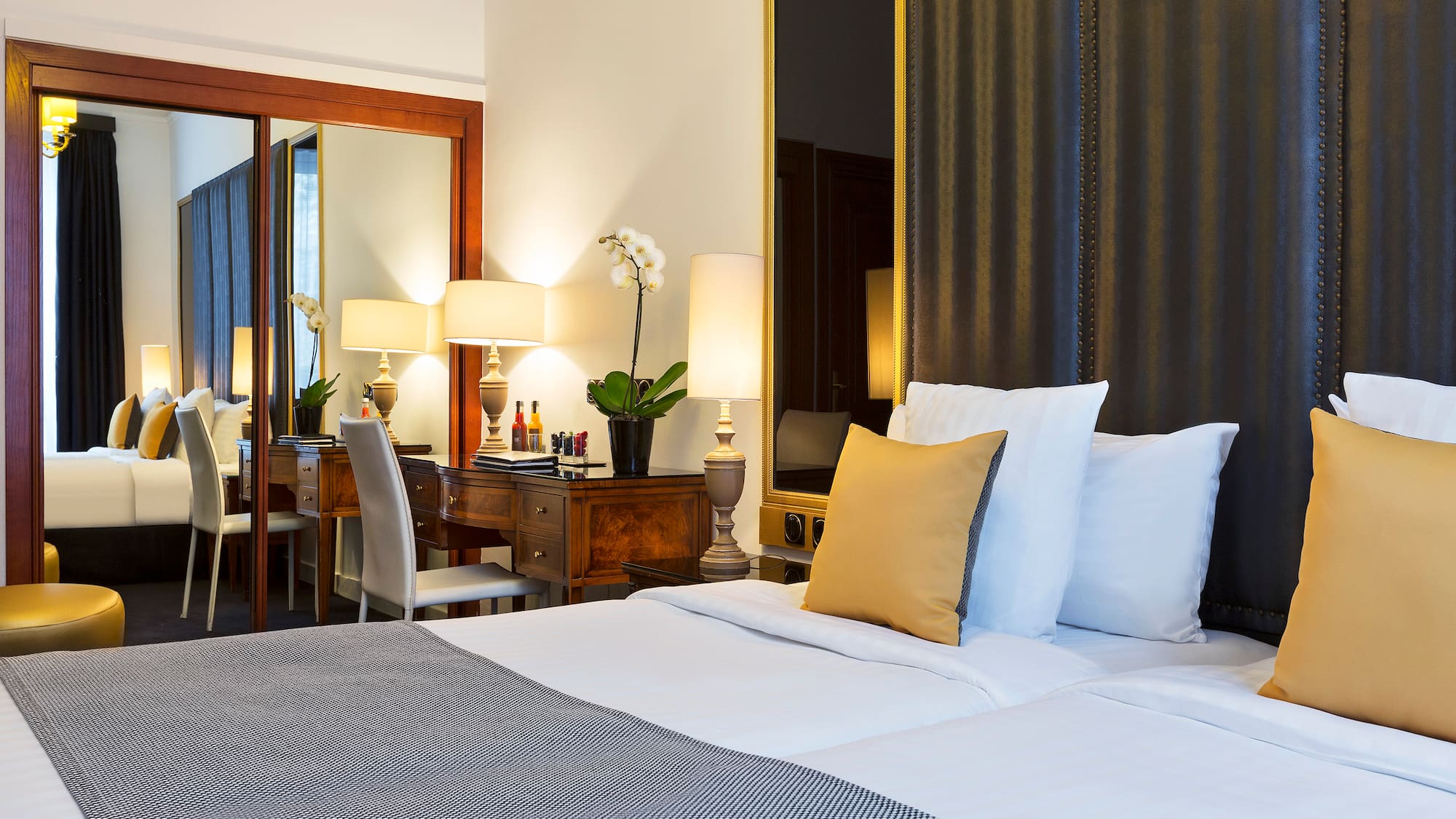 a bed with white sheets and pillows in a hotel room