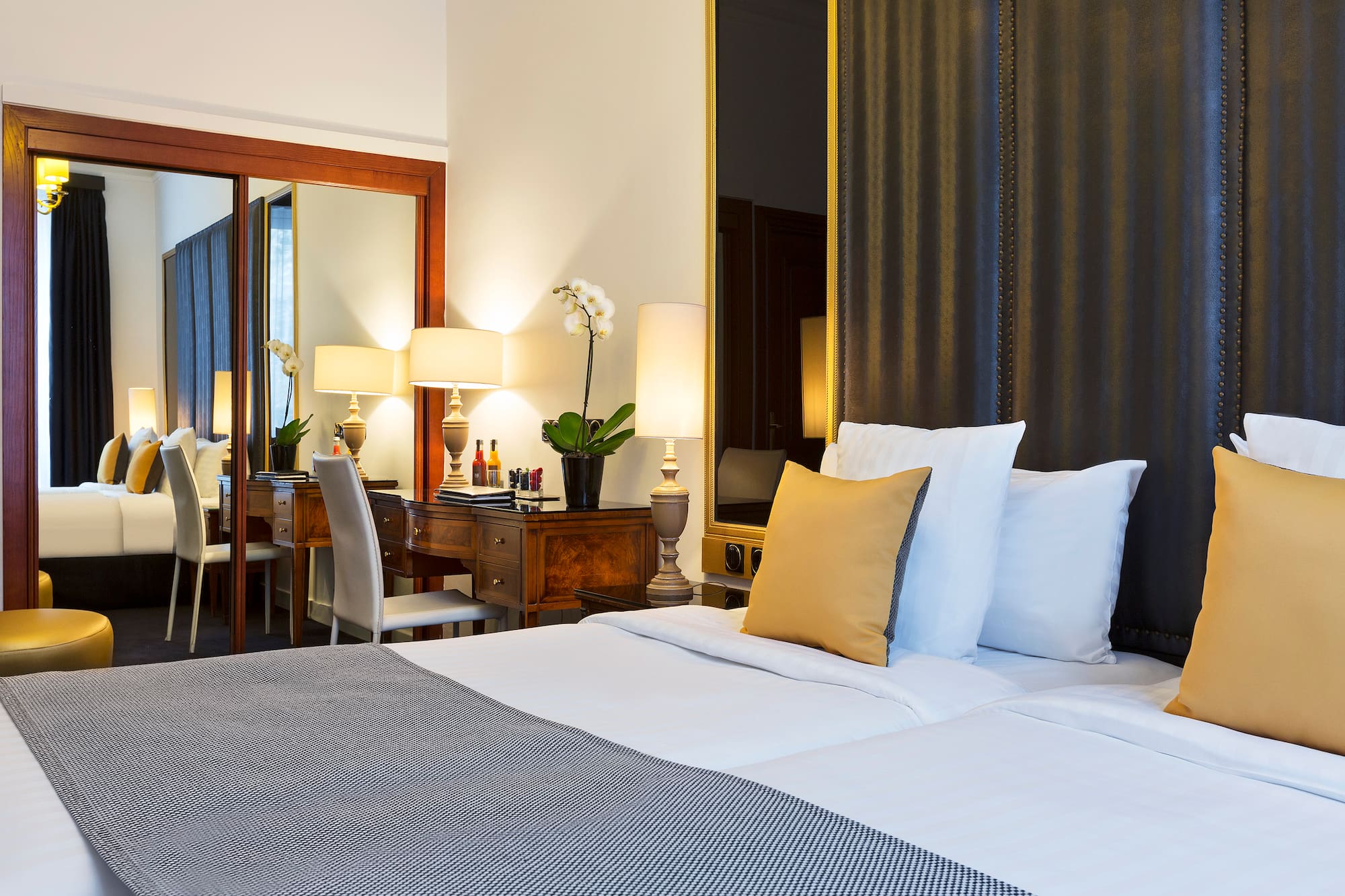a bed with white sheets and pillows in a hotel room
