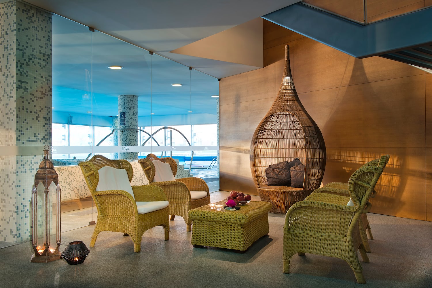 a room with wicker furniture and a glass wall