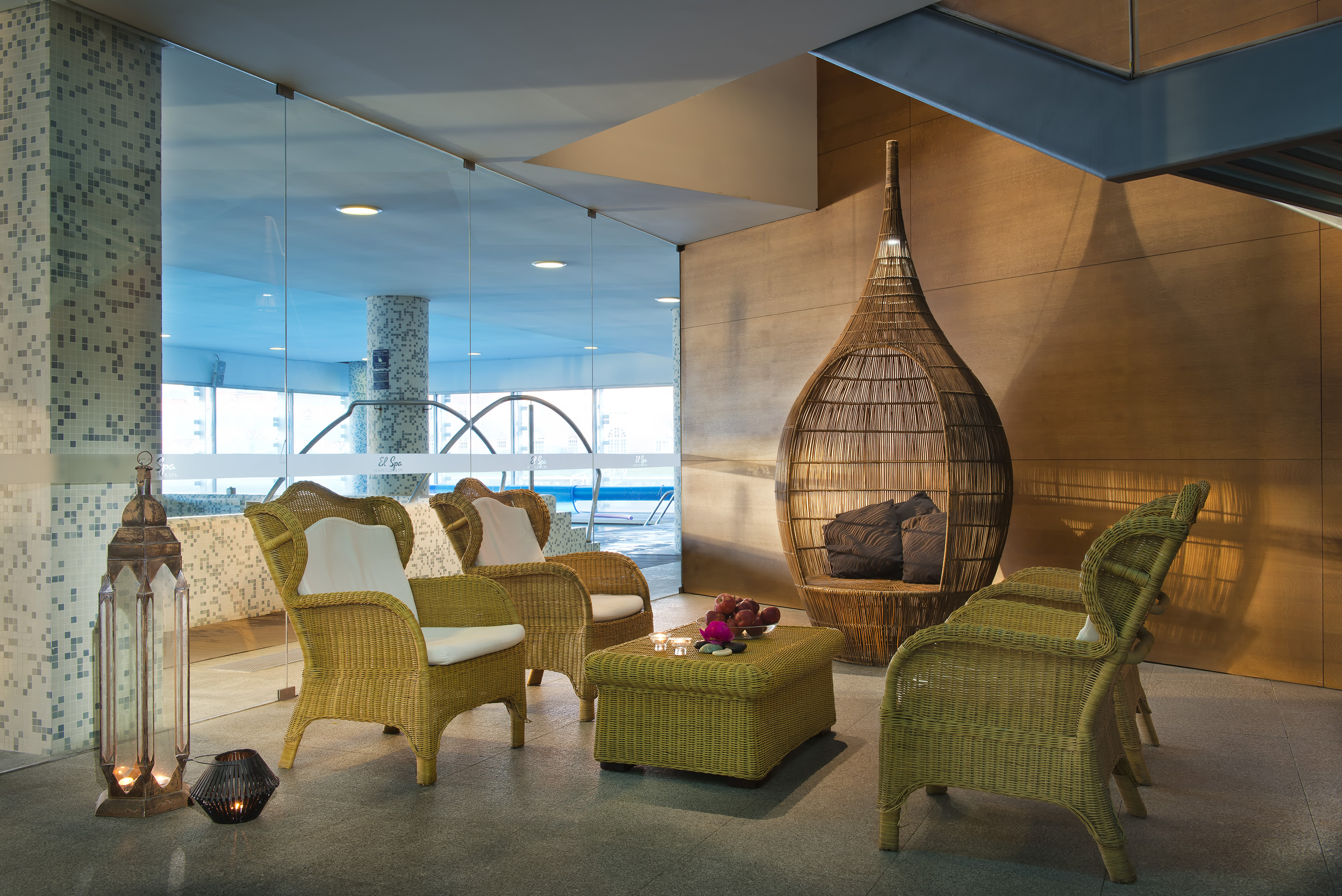 a room with wicker furniture and a glass wall