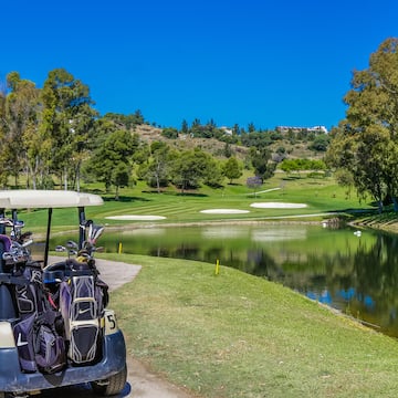 a golf cart parked next to a pond