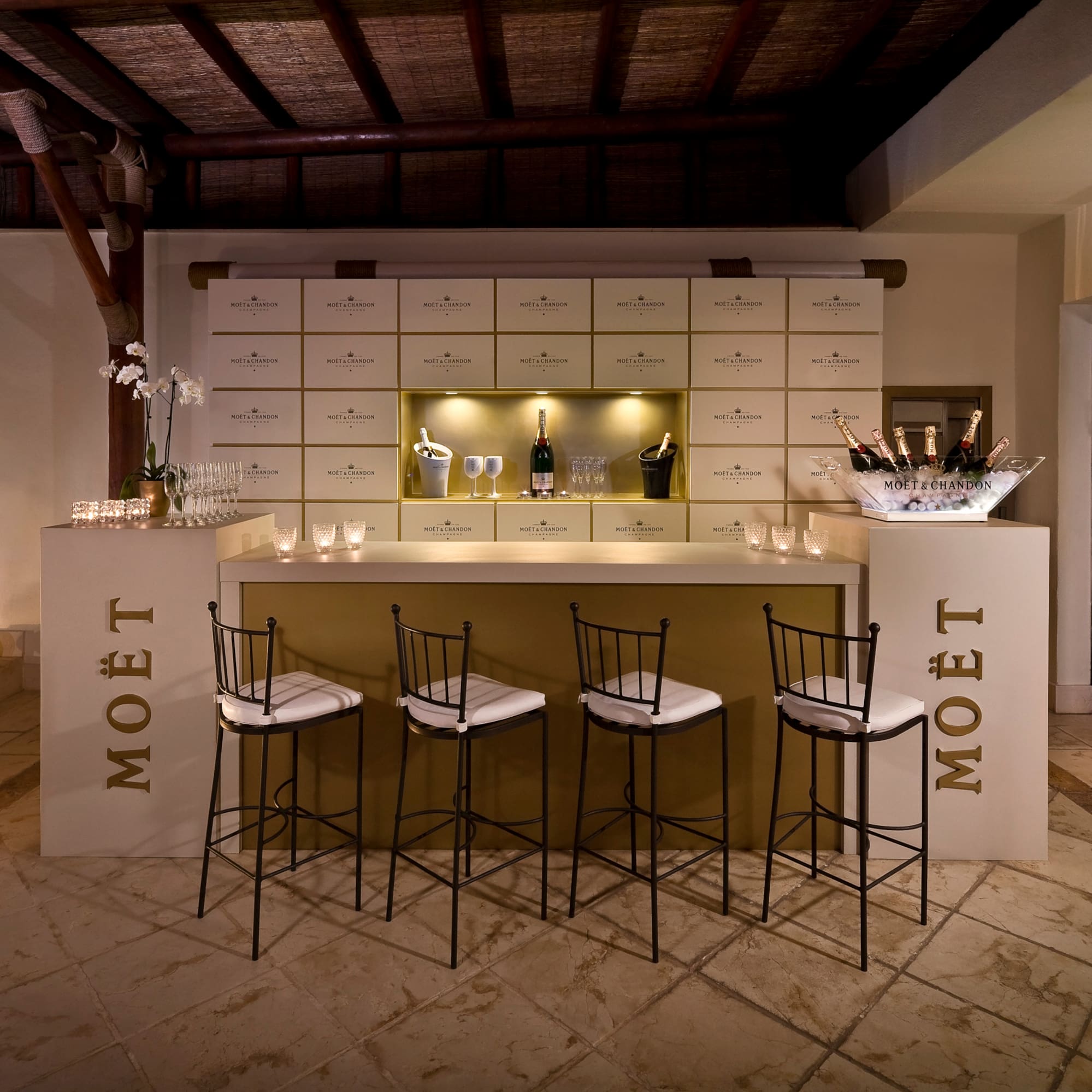 a bar with chairs and a bottle of champagne