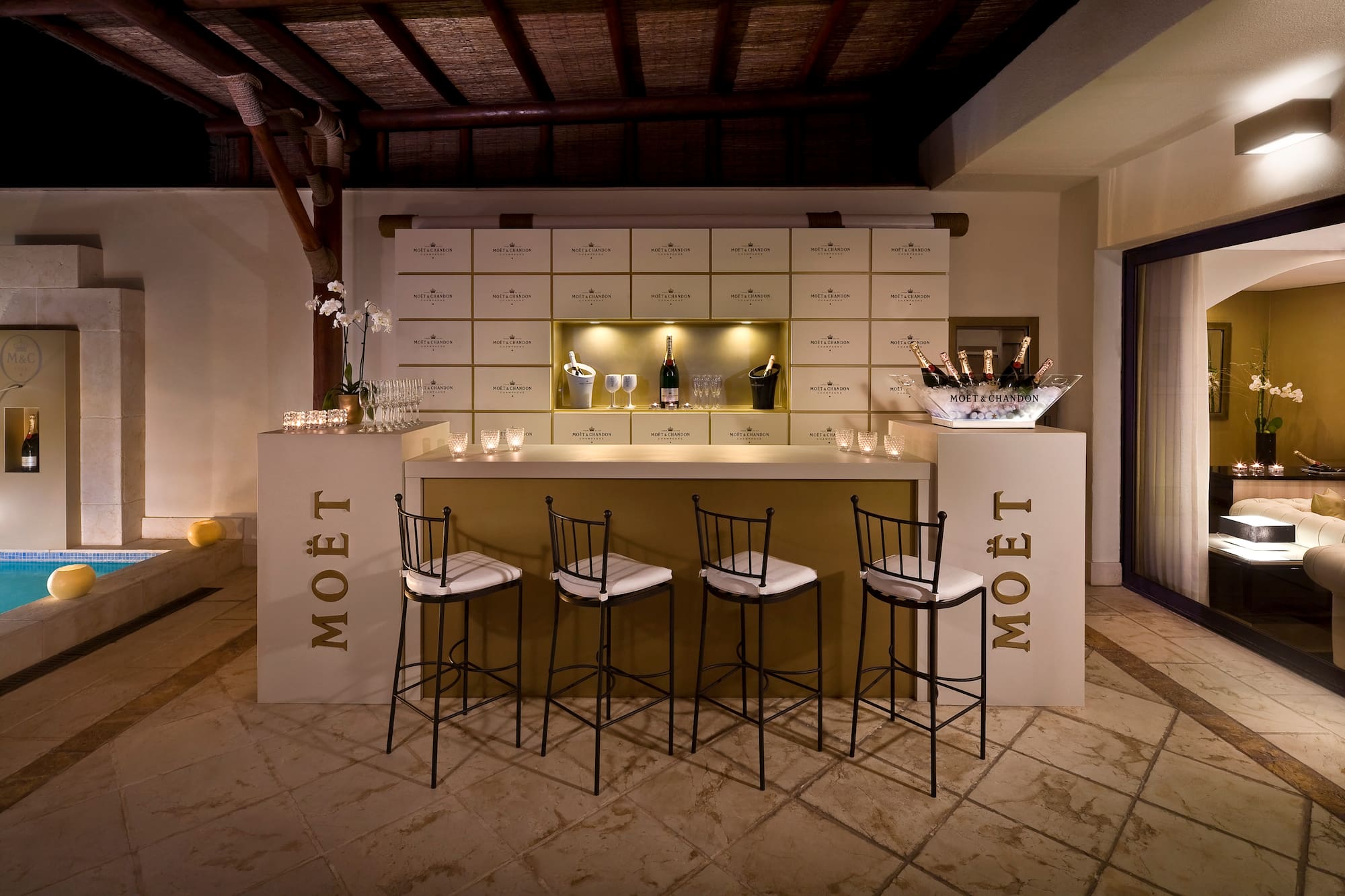 a bar with chairs and a bottle of champagne