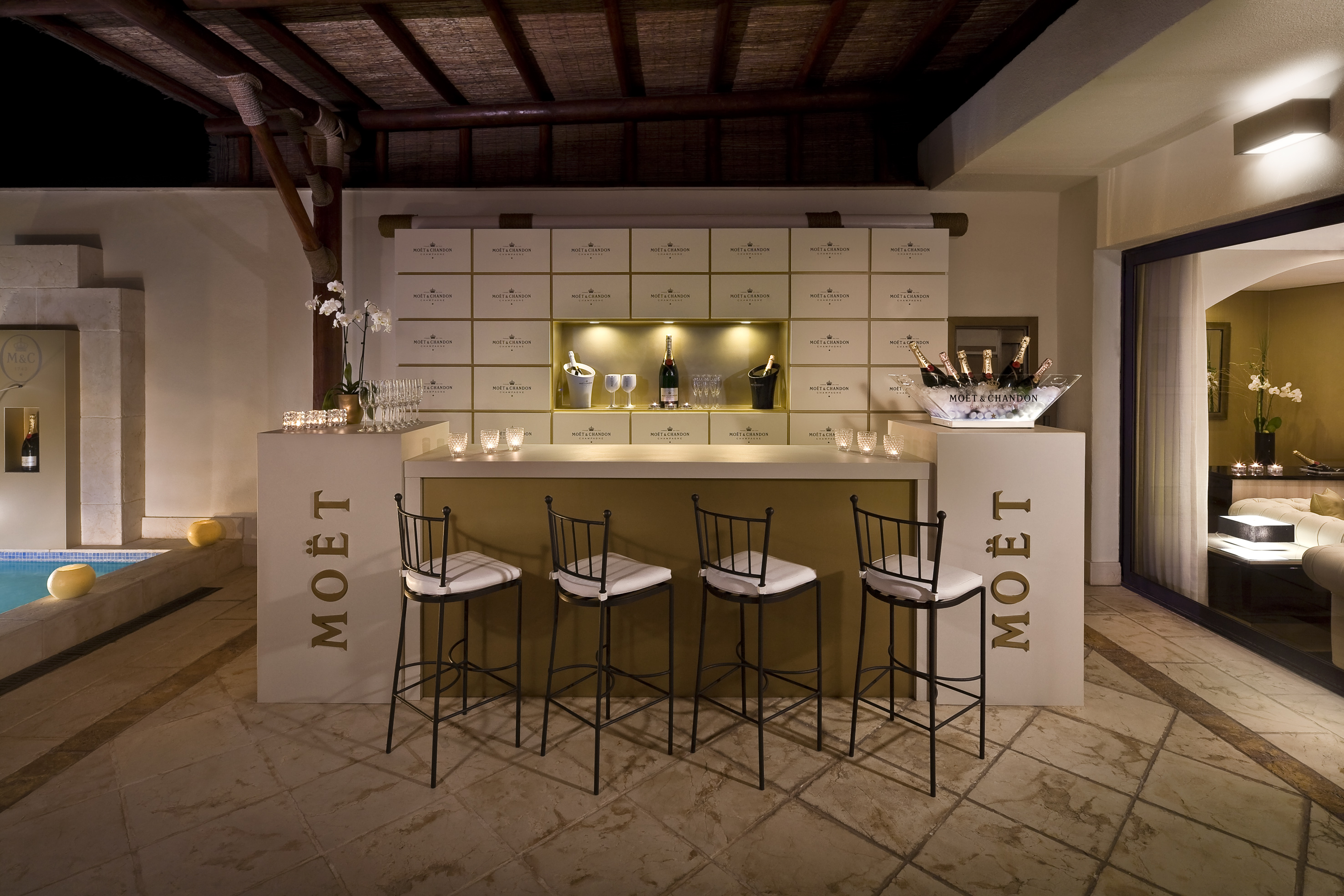 a bar with chairs and a bottle of champagne