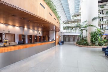 a lobby with a large building with plants and a large ceiling