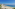 a beach with people and boats on the water