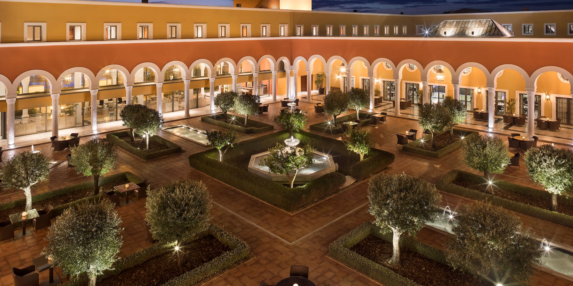 a courtyard with trees and a fountain