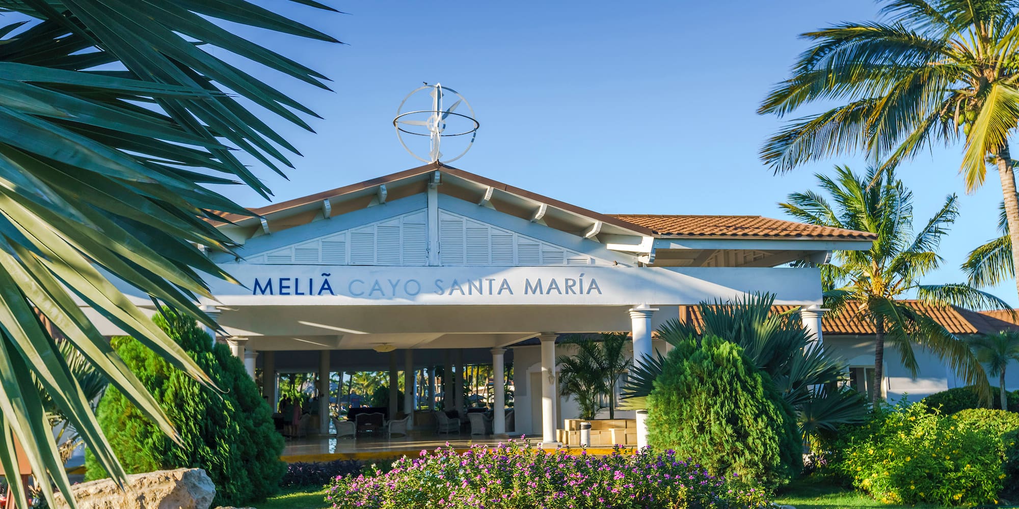 a building with a white roof and a garden