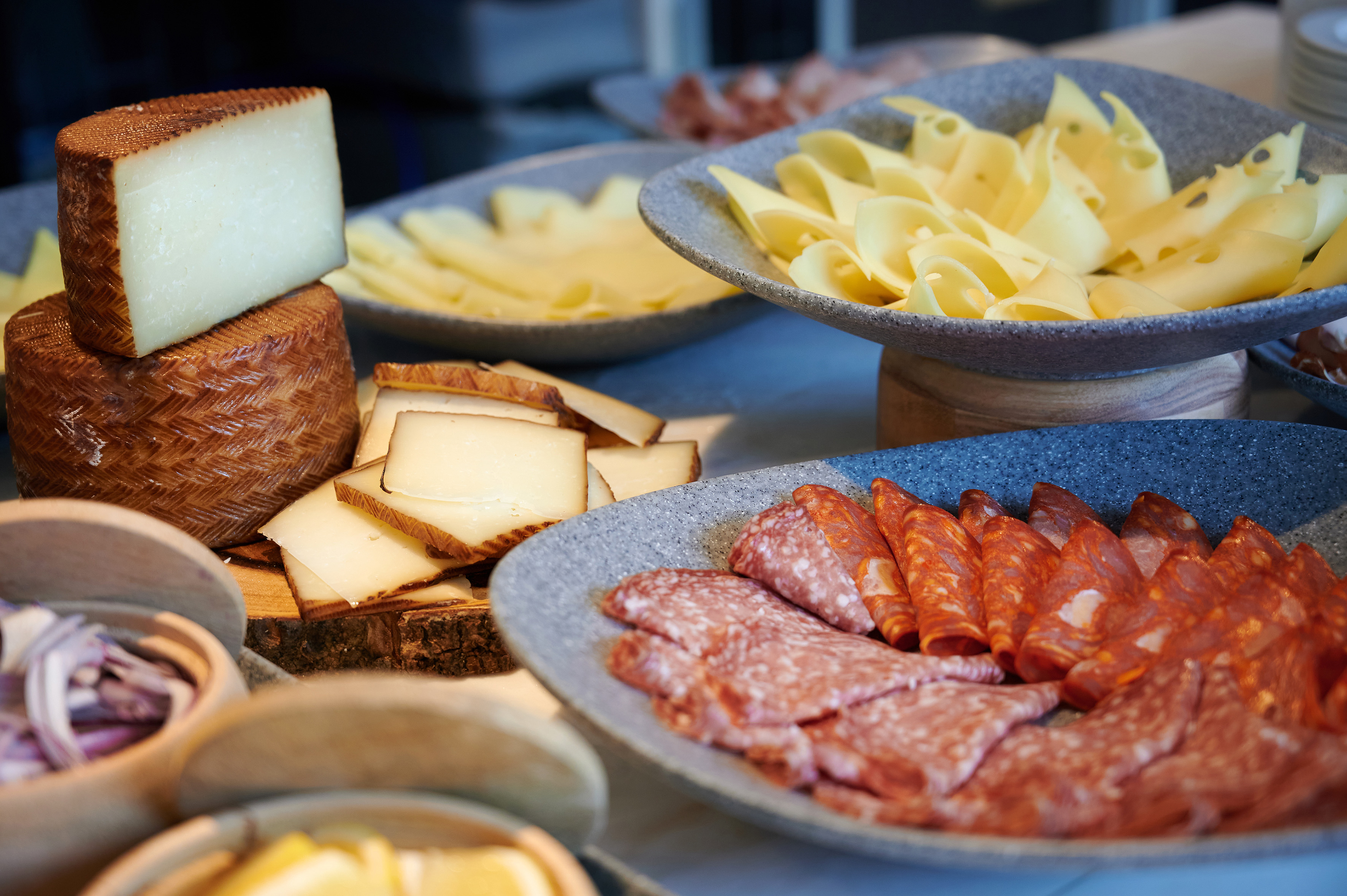 Charcuterie board with cheeses, sliced salami, and chorizo platter.