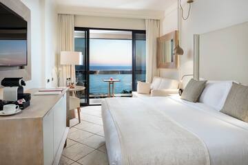 a room with a bed and a window overlooking the ocean