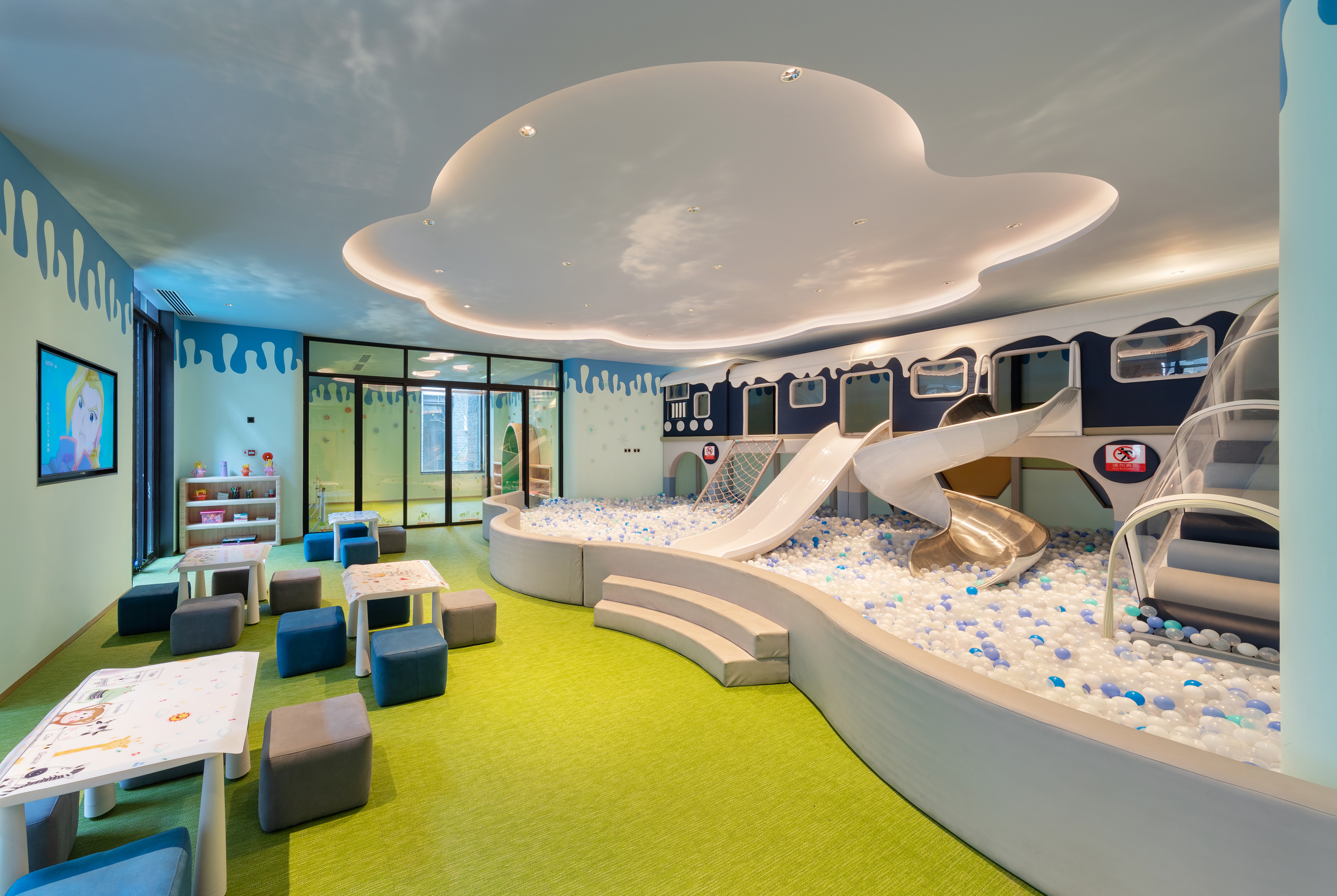 Vibrant indoor play area with ball pit, slides, and train-themed structure.