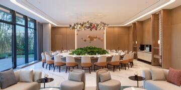 a large round table with chairs and a chandelier