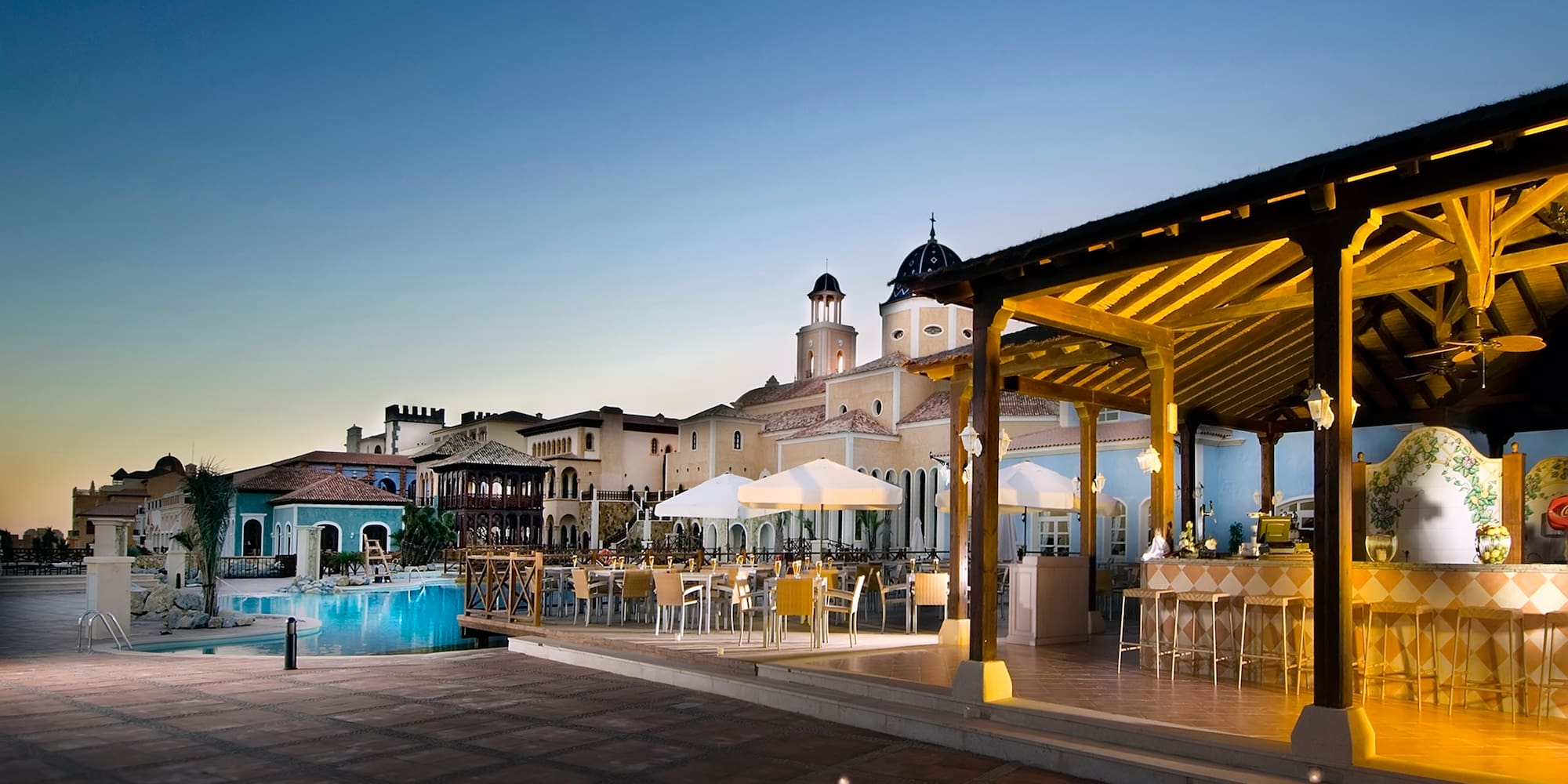 a pool and tables in a resort