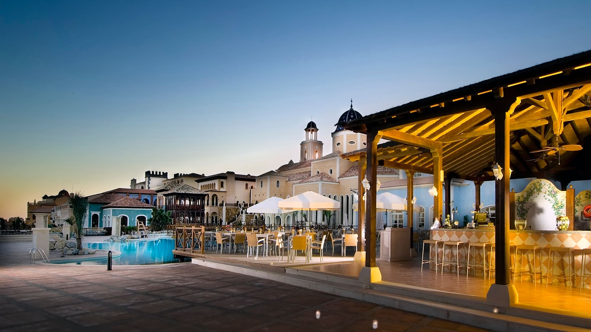 a pool and tables in a resort