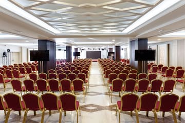 a room with red chairs and a screen