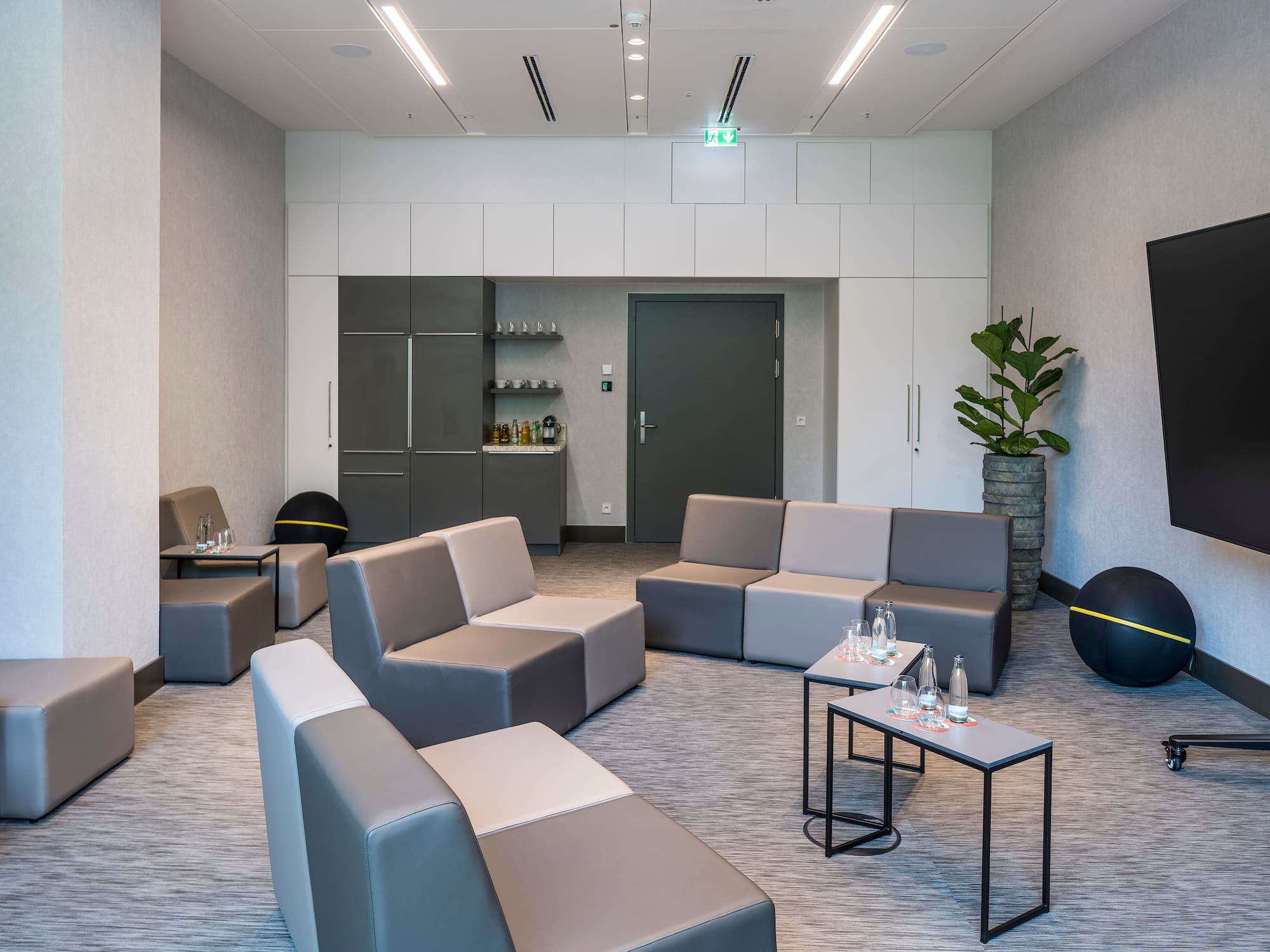 a room with grey couches and black balls