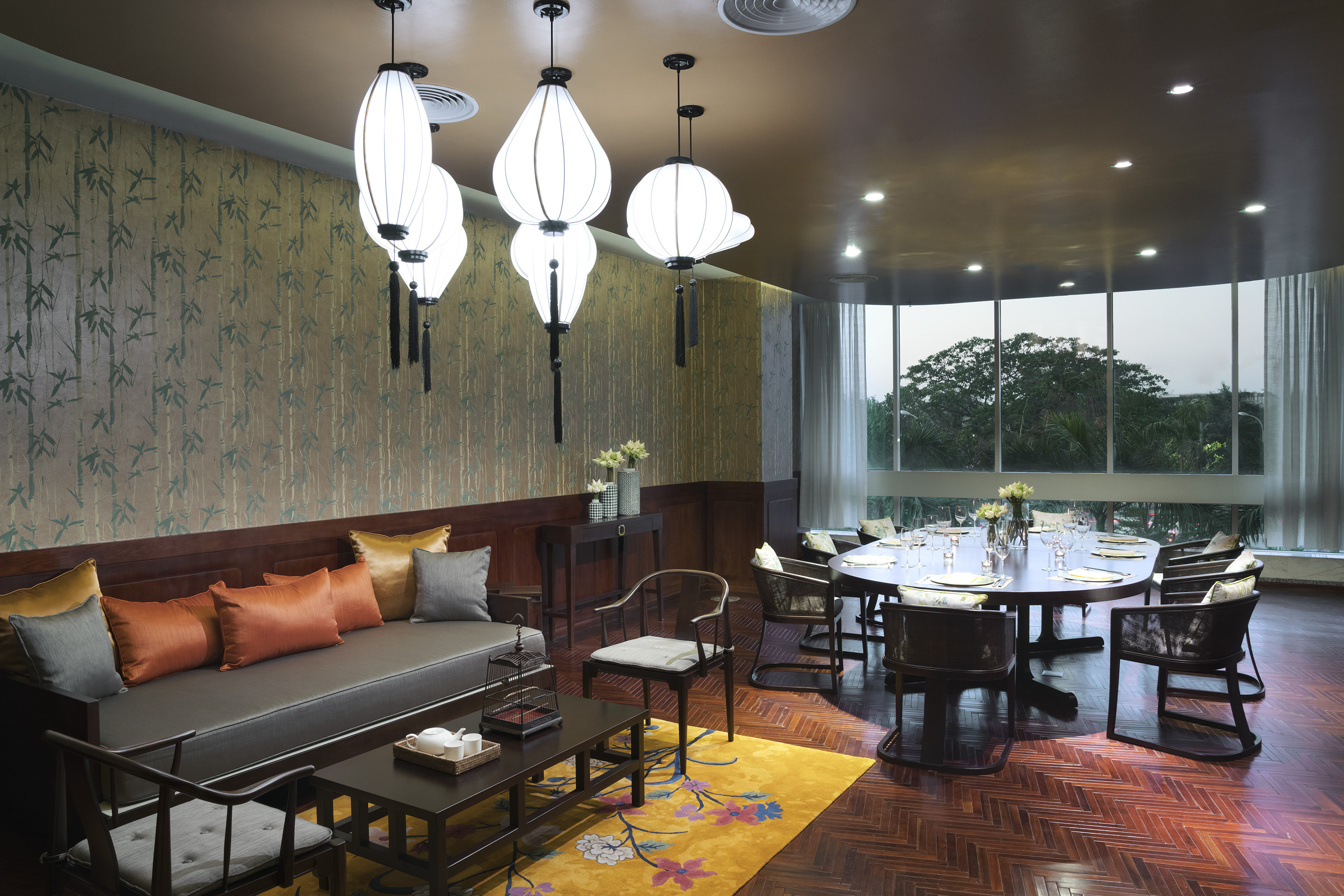 Asian luxury private dining room with lounge, bamboo wall, and window view.