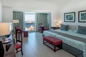 a bedroom with a bed and chairs and a table