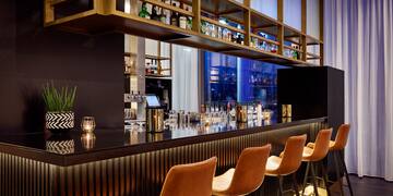 a bar with chairs and a shelf