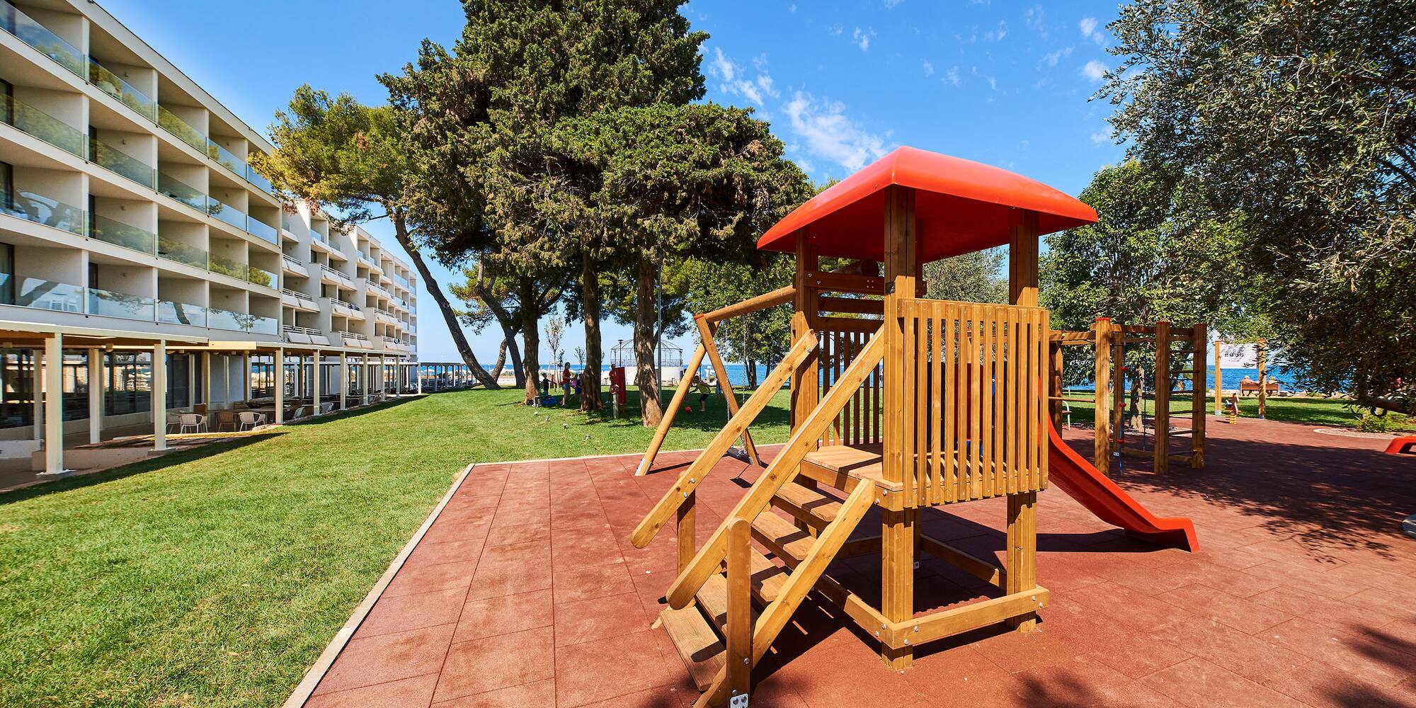 a playground with a slide and trees in the background
