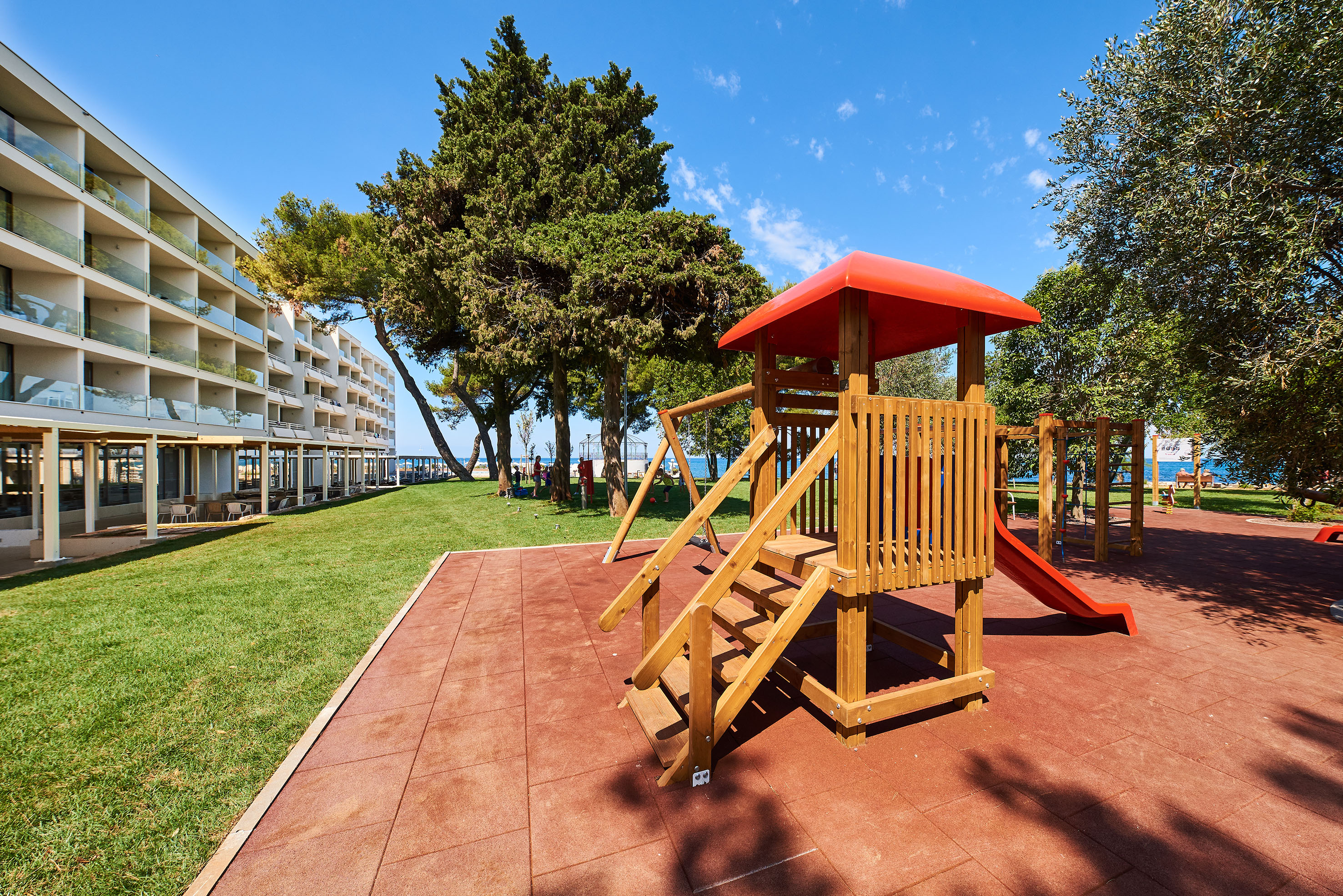 a playground with a slide and trees in the background
