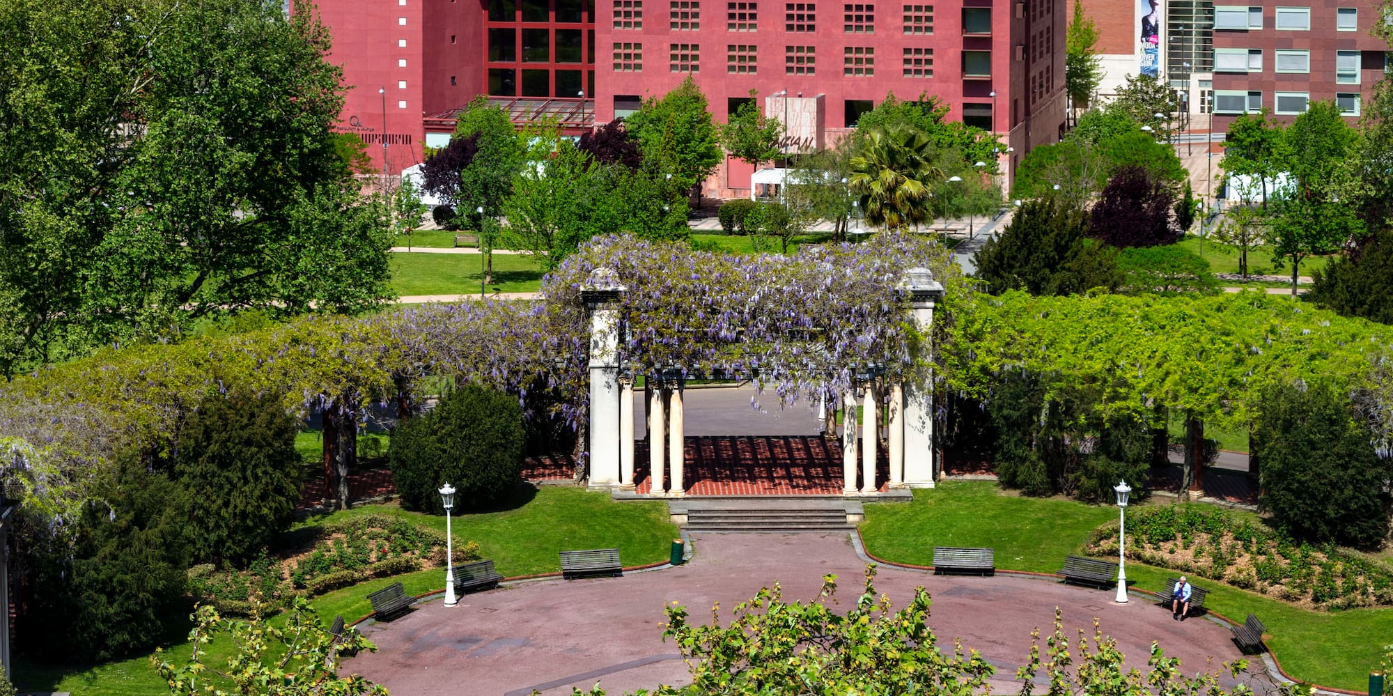 a park with a fountain and buildings in the background