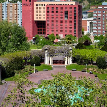 a park with a fountain and buildings in the background