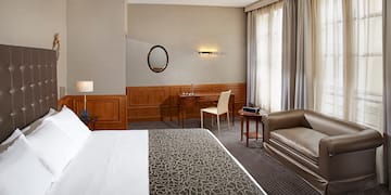 a hotel room with a bed and a chair