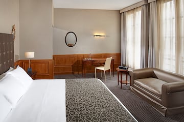a hotel room with a bed and a chair