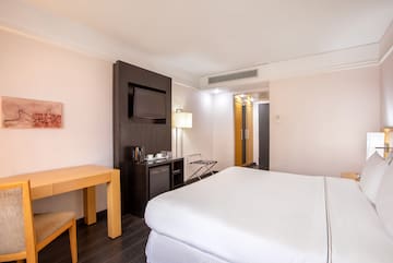 a room with a bed and a television